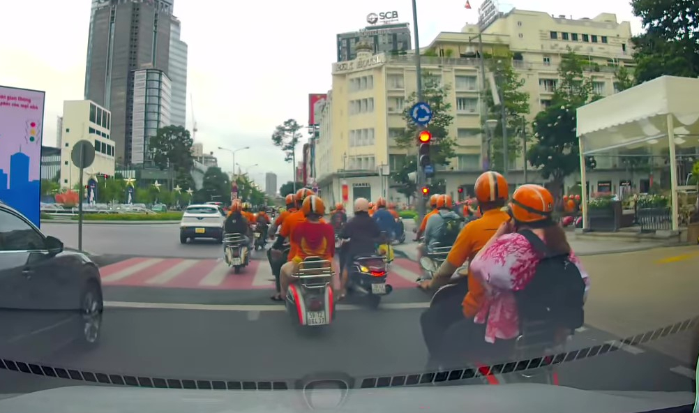 Lập biên bản 10 người mặc áo cam chạy Vespa vượt đèn đỏ ở trung tâm TP.HCM - Ảnh 1.