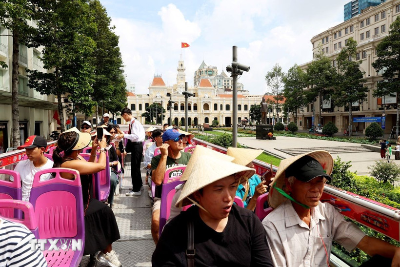 Khách quốc tế tham quan trung tâm Thành phố Hồ Chí Minh bằng xe bus hai tầng. (Ảnh: Hồng Đạt/TTXVN)
